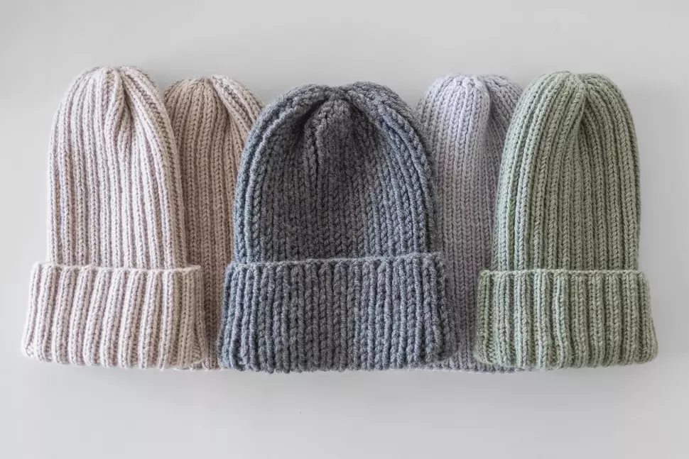 Five different colored knit hats from above